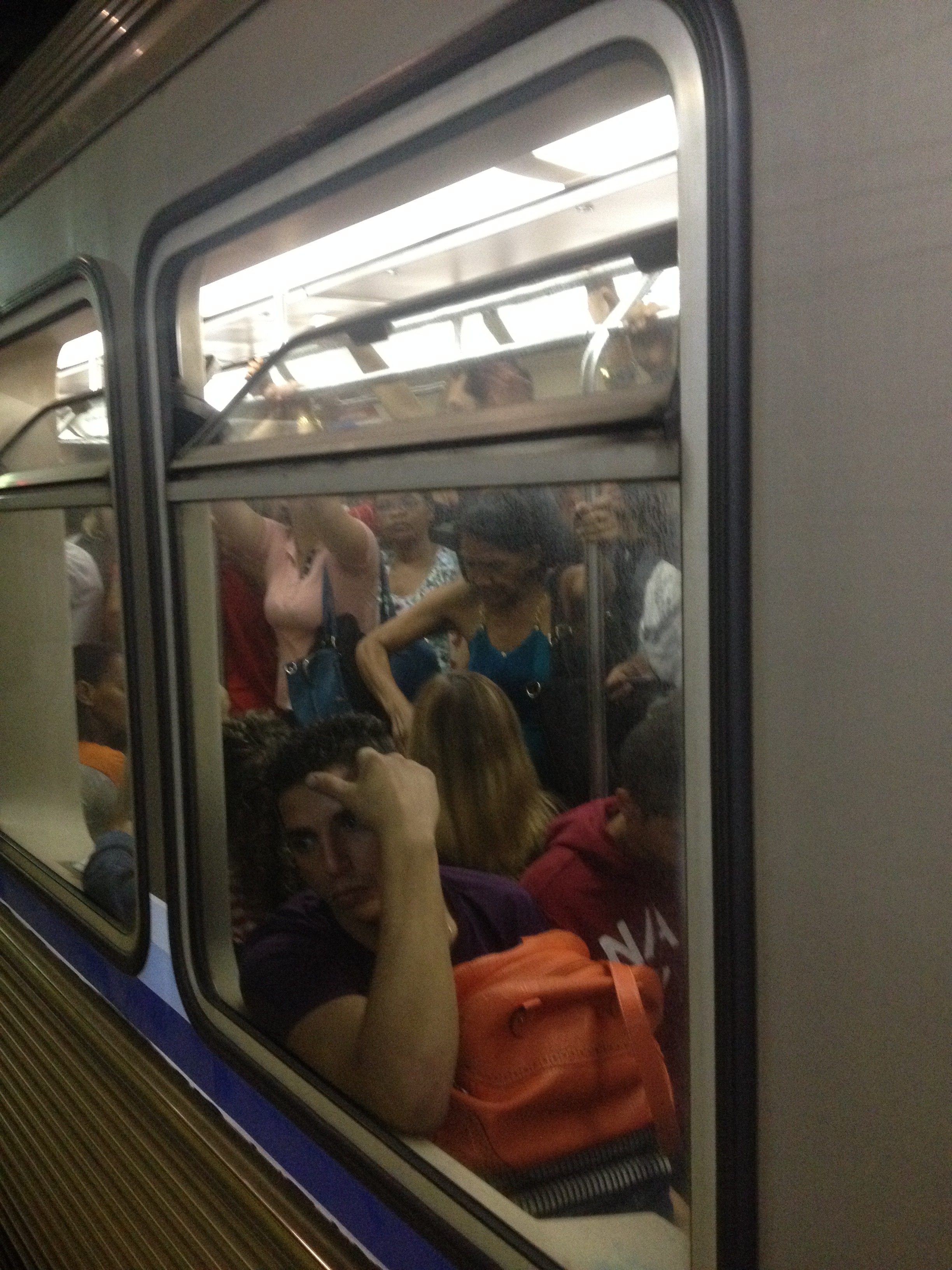 Trem lotado visto da plataforma de embarque