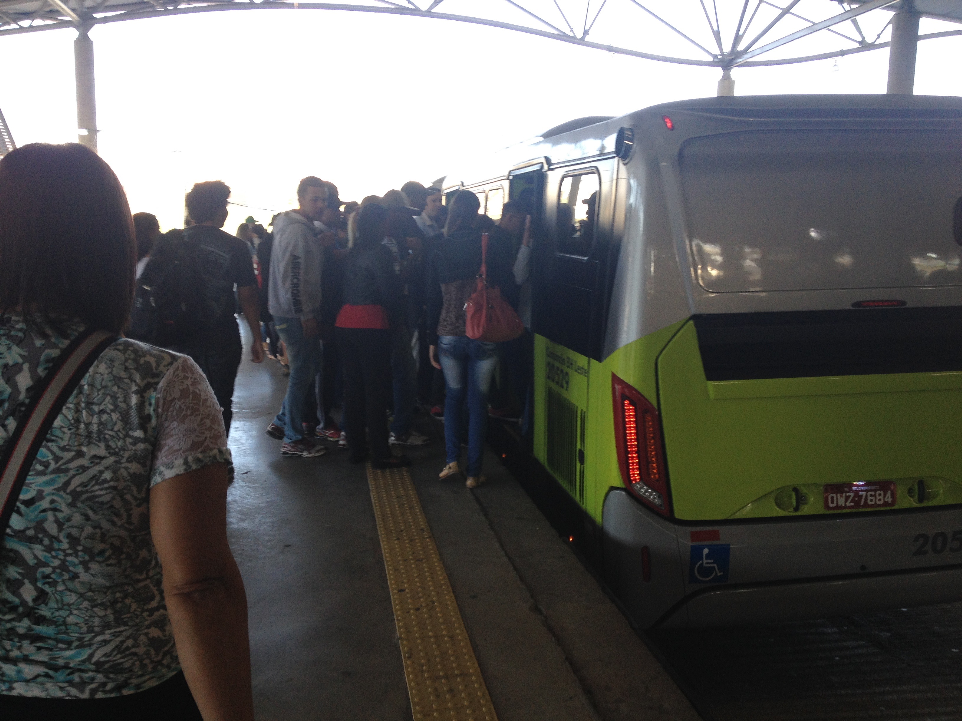 ônibus do brt na plataforma, com passageiros amontoados nas portas de entrada e saída